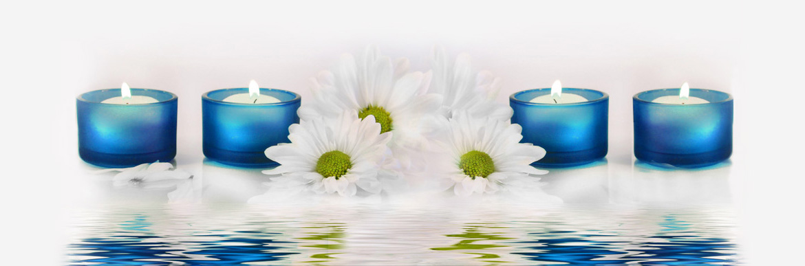 A white flower with green center and blue vase in water.